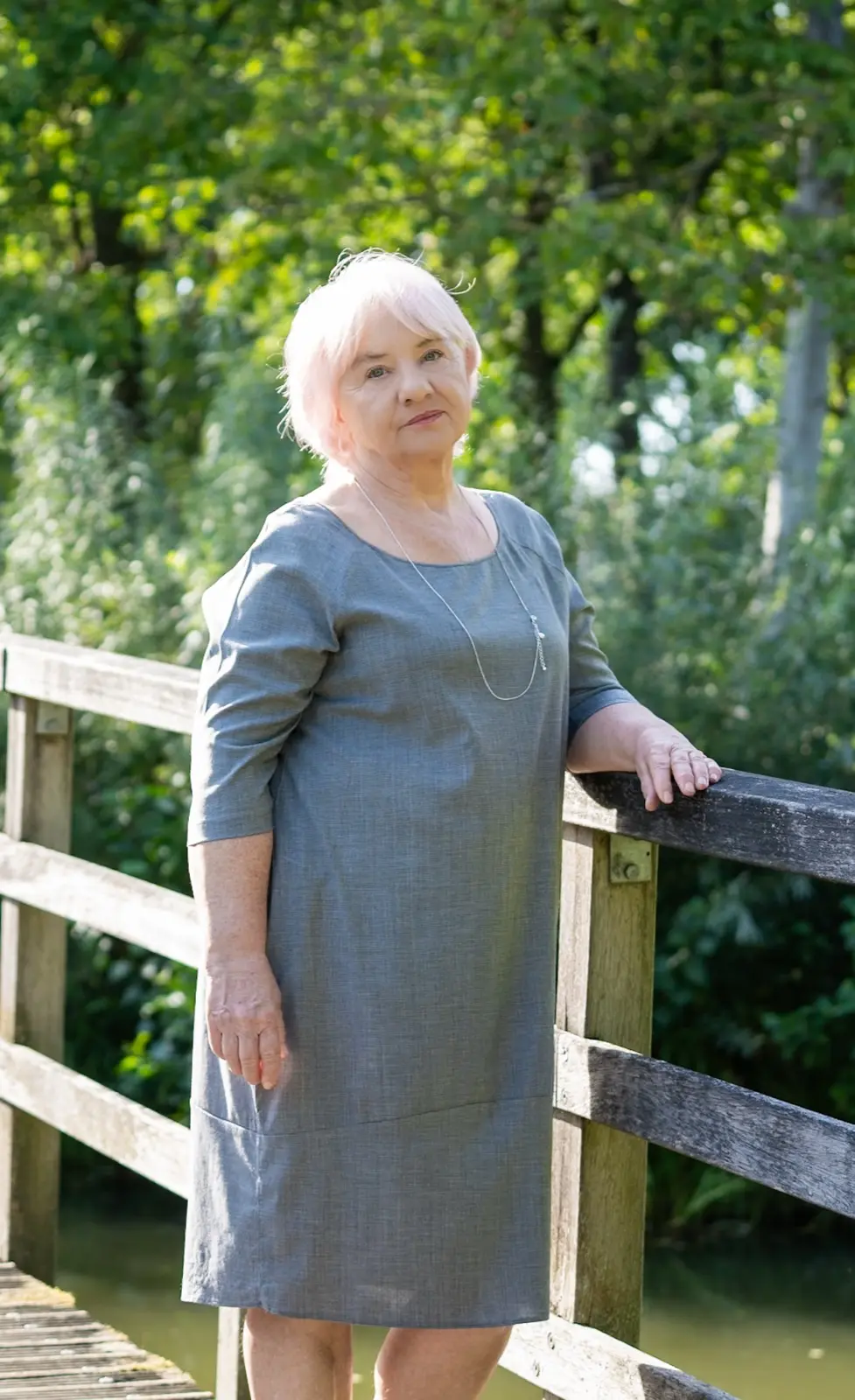 Basia stojąca na drewnianym mostku wśród zieleni