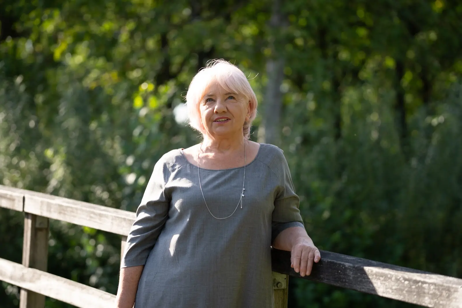 Basia patrząca z nadzieją w górę, na tle drzew