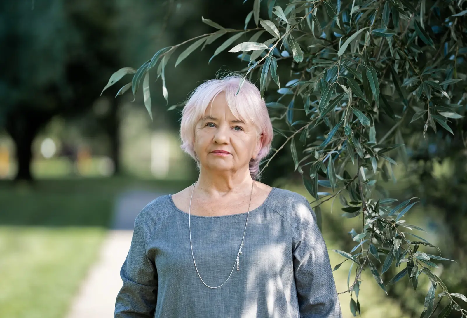 Basia wśród gałęzi wierzby, spokojnie patrząca przed siebie